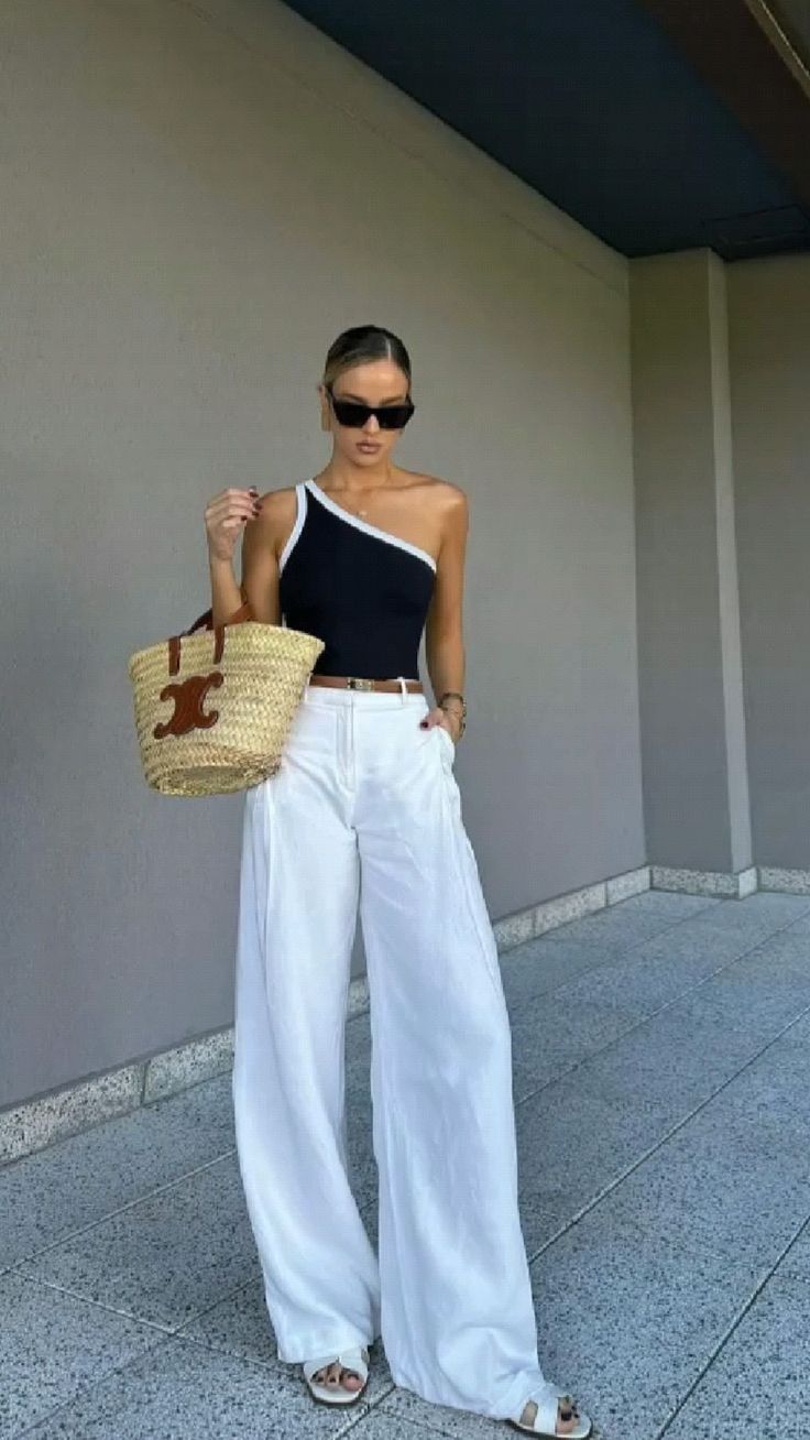 white wide-leg trousers paired with a LOEWE straw bag